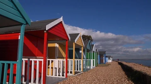 Dolly shot of brightly coloured beach huts Stock Footage