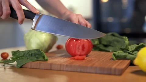 Dolly shot of camera. Woman's hands cutting fresh tomato on wooden cutting board 스톡 동영상 152651936