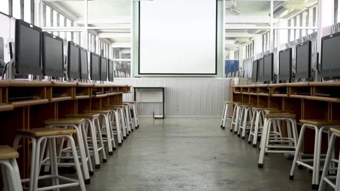 Dolly shot of computer laboratory room towards projector white screen 스톡 동영상 94366807