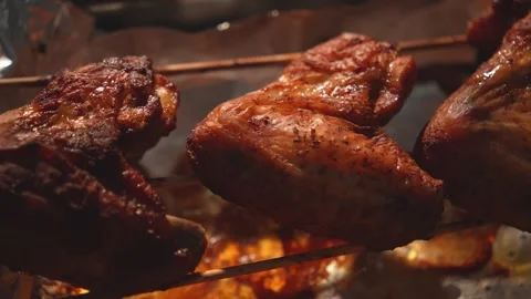 Dolly shot of crispy roasted chicken wings on skewers close-up Stock Footage 312647894