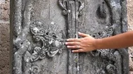 Dolly Shot Of The Cute Girl Touching Medieval Cross Carved In Stone. Slow Motion Stock Footage