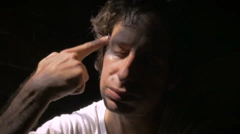 Dolly shot of a depressed man points an imaginary gun to his head and shoots. Stock Footage 58118417
