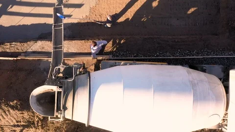 Dolly shot with a drone flying over a cement mixer that pours cement Stock Footage 116893870