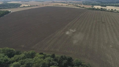 Dolly Shot By Drone Of Tractor Moving Away From Camera While Ploughing Field Video stock 93236566