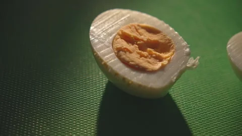 Dolly shot of egg halves with yolk on green cutting board Stock Footage 312767236
