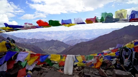 Dolly shot forward through an arch of Tibetan prayer flags in the wind as Vídeo Stock 123697238