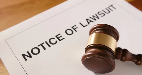 Dolly Shot Of Gavel Over Notice Of Lawsuit Text 4K Stock Footage