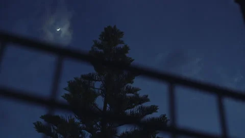 Dolly shot of the half moon through the window railing Stock Footage 130907041