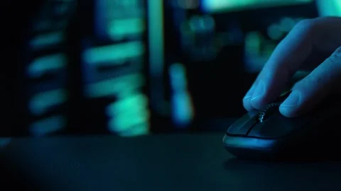 Dolly shot of a hand operating a mouse with ambient computer glow. Stock Footage 267860794