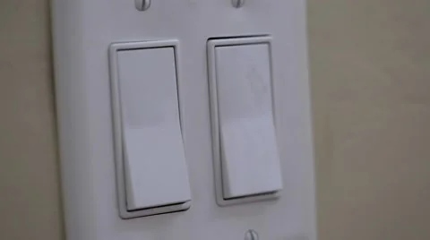 A dolly shot of hand turning on and off light switch Stock Footage 45987983