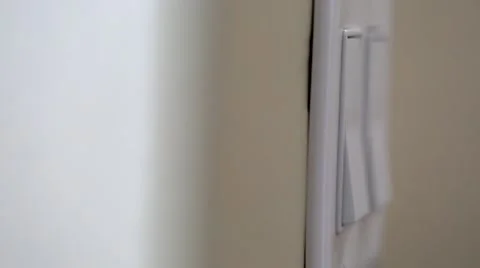 A dolly shot of hand turning on light switch Stock Footage 45987574