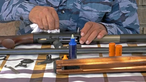 Dolly shot of hunter cleaning his disassembled gun Stock Footage 82803147
