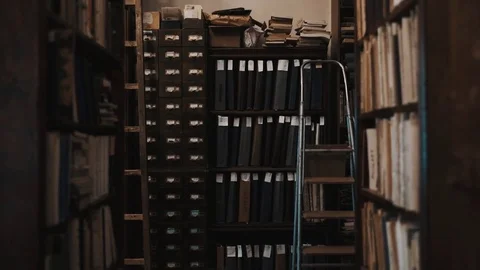 Dolly shot interior of old library bookshelves with document folders Stock Footage 71927047