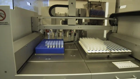 Dolly shot of a machine used to take caps off of virus samples. Stock Footage 127532855