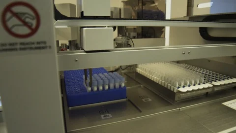 Dolly shot of a machine used to take caps off of virus samples. Stock Footage 127532867