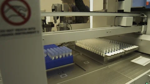 Dolly shot of a machine used to take caps off of virus samples. Stock Footage 127532917