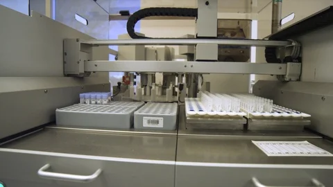Dolly shot of a machine used to take caps off of virus samples. Stock Footage 127533041