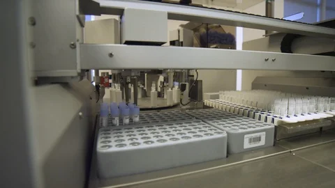 Dolly shot of a machine used to take caps off of virus samples. Stock Footage 127533120