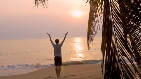 Dolly shot of a man doing yoga on the beach at sunrise Stock Footage 90589413