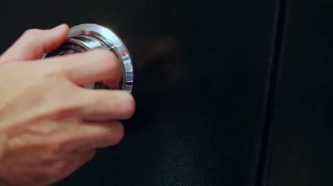 A dolly shot of a man turning the combination on a safe Stock Footage 57758964