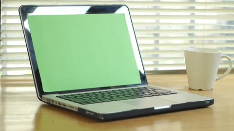 Dolly shot - man typing on computer laptop keyboard with green screen monitor Stock Footage 56930857