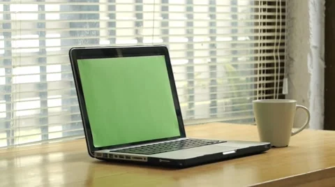Dolly shot - man typing on computer laptop keyboard with green screen monitor Stock Footage 56930996