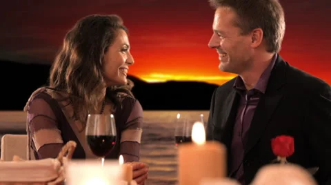 Dolly shot of mid aged couple at dinner giving rose Stock Footage 43676001
