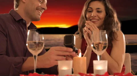 Dolly shot of mid aged couple at dinner giving ring Stock Footage 43676049