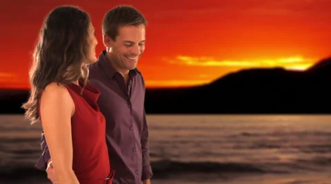 Dolly shot of mid aged couple walking in sunset Stock Footage 43676069