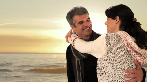 Dolly shot of mid aged couple walking in sunset Stock Footage 43676509