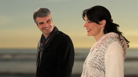 Dolly shot of mid aged couple walking by beach Stock Footage 43676517