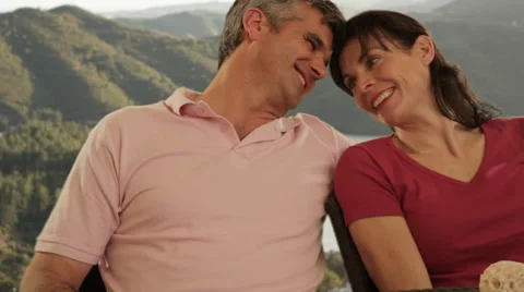 Dolly shot of mid aged couple sitting in countryside Stock Footage 43676586