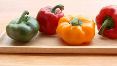 Dolly shot Multi Colored Bell Pepper Placed on wood plate Stock Footage 154923940