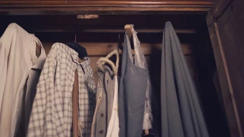 Dolly shot of old-fashioned clothes in a wooden wardrobe. Vintage fashion. Stock-Footage 75051547
