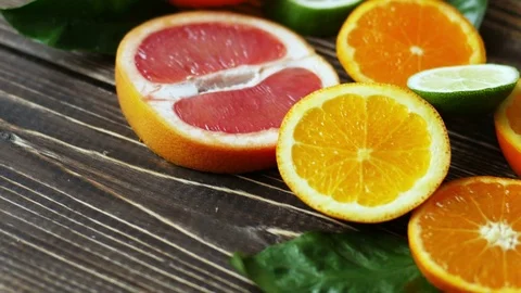 Dolly shot of orange, lime, grapefruit slices on wooden table. 4k Video stock 71453685