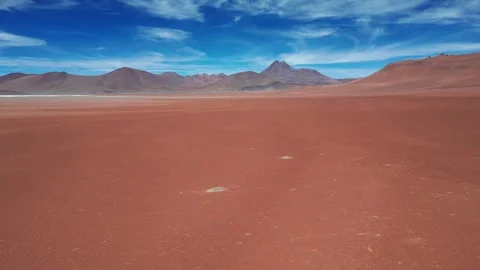 Dolly shot over vast red desert plain with salt patches gliding toward dramatic Stock Footage 334853226