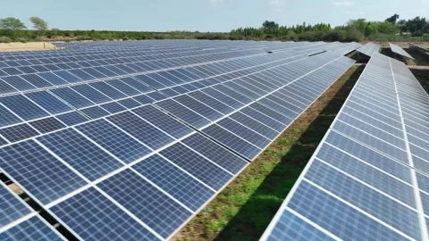 Dolly shot past rows of solar panel energy array angled toward the sun Vídeo Stock 345329711