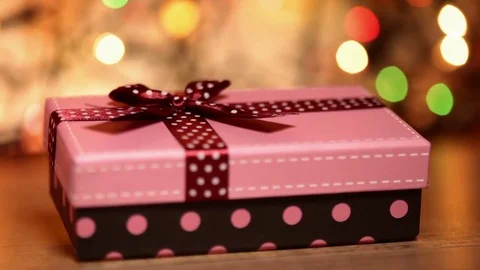Dolly shot of present box against blurry lights Видео 80908942