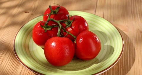 Dolly shot red tomatoes with water drops on a plate. Stock Footage 246306163