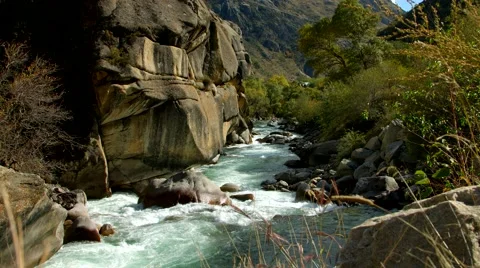 A dolly shot of the running river through the narrow valley 動画素材 58743480