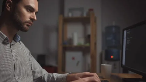 Dolly shot of serious computer programmer working in the office Stock Footage 75014979