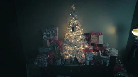 Dolly shot of a small Christmas tree with glowing lights and ornaments Stock Footage 145669657