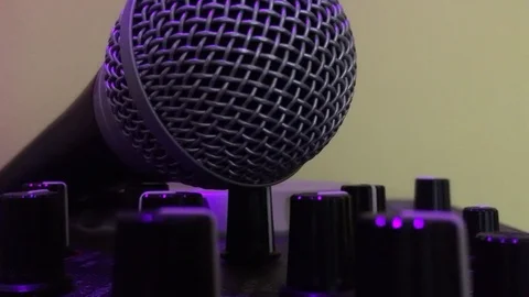 Dolly shot of stage microphone on an audio mixer with dials Stock Footage 98342200
