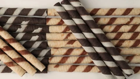 Dolly shot of striped chocolate rolled wafer sticks isolated on white background Stock Footage 342437852