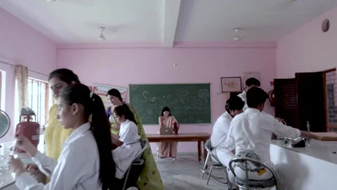 Dolly in shot Students performing Experiment in Lan under supervision of Teacher Video stock 157057280