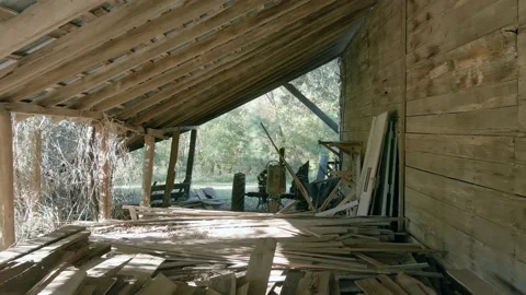 Dolly shot through old barn containing a vintage tractor Stock Footage 166112186