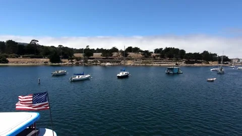 Dolly in shot through pier railing onto yachts on water in summer American flag Stock Footage 143426241