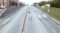 Dolly shot timelapse city traffic, cars drive under bridge, day HD Footage