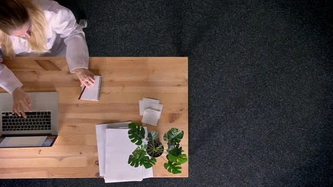 Dolly shot of top down view of formally-dressed woman working and making notes Video stock 99411070