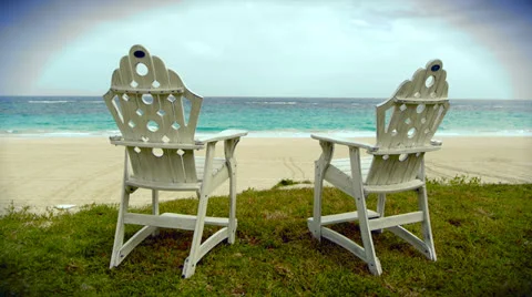 Dolly shot of two rustic chairs at the beach shoreline Stock Footage 23435071